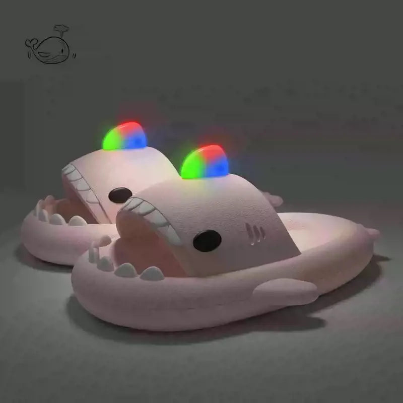 Plush shark toy with glowing rainbow eyes on a dark background