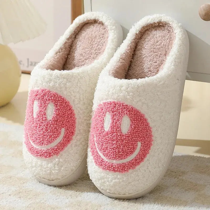 White slippers with pink smiley face design on a light background