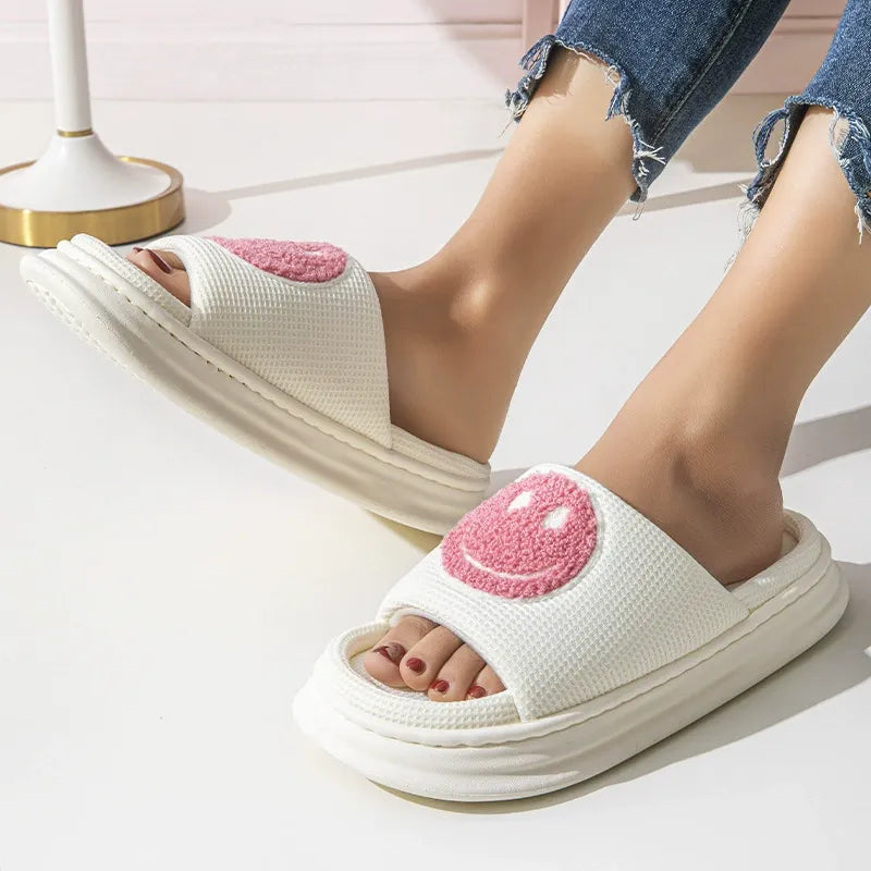 White slides with pink heart designs worn by a person on a light background