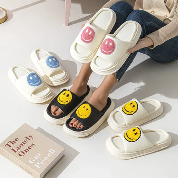 Smiley face slippers on a light surface with a book titled 'The Lonely Ones' by Carole Woll.