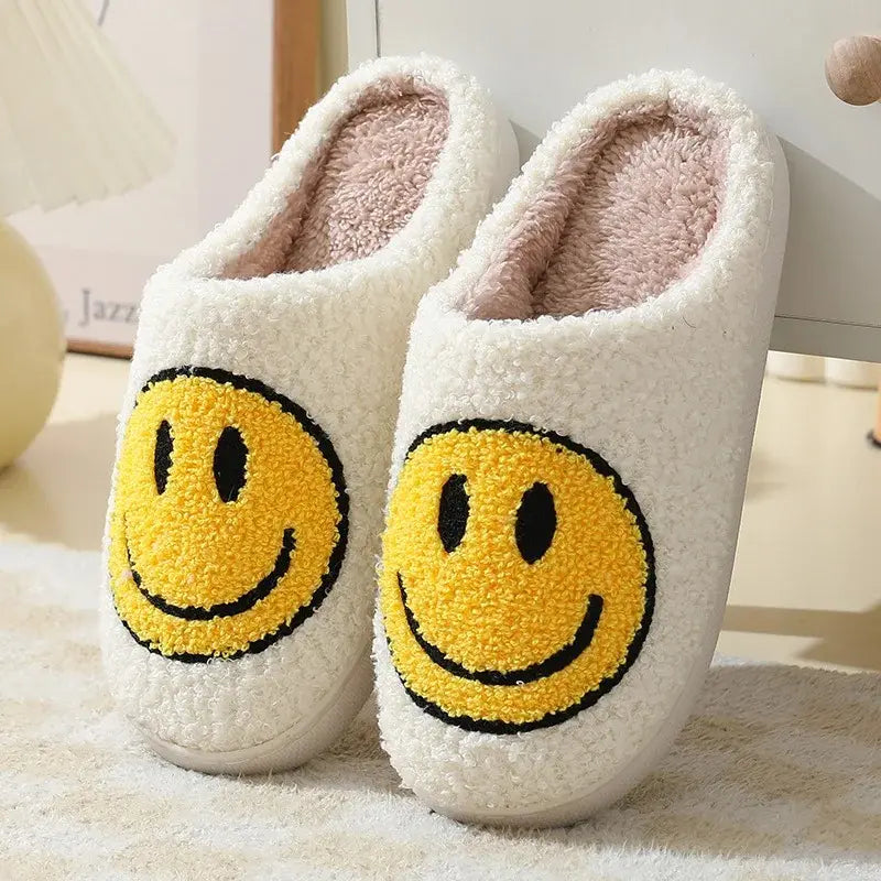 White slippers with yellow smiley face designs on a light background