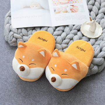 Pair of novelty slippers on a textured surface with a magazine in the background.