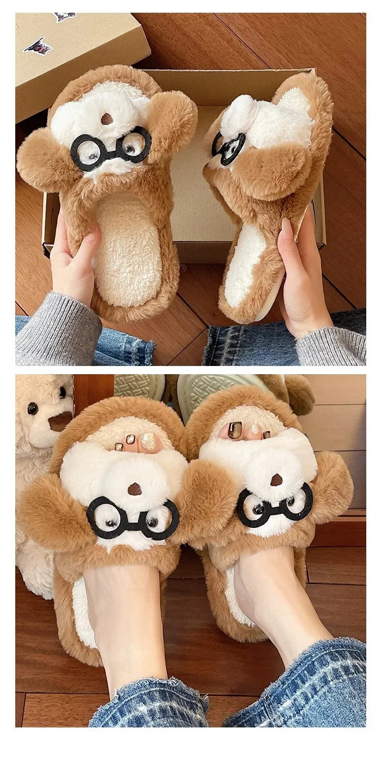 Pair of plush monkey slippers with glasses held by a person on a wooden floor.