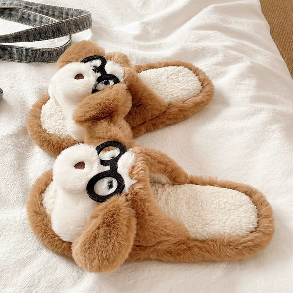 Pair of brown and white slippers with a dog design on a white surface
