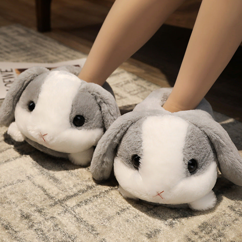 Pair of gray bunny slippers on a checkered floor.