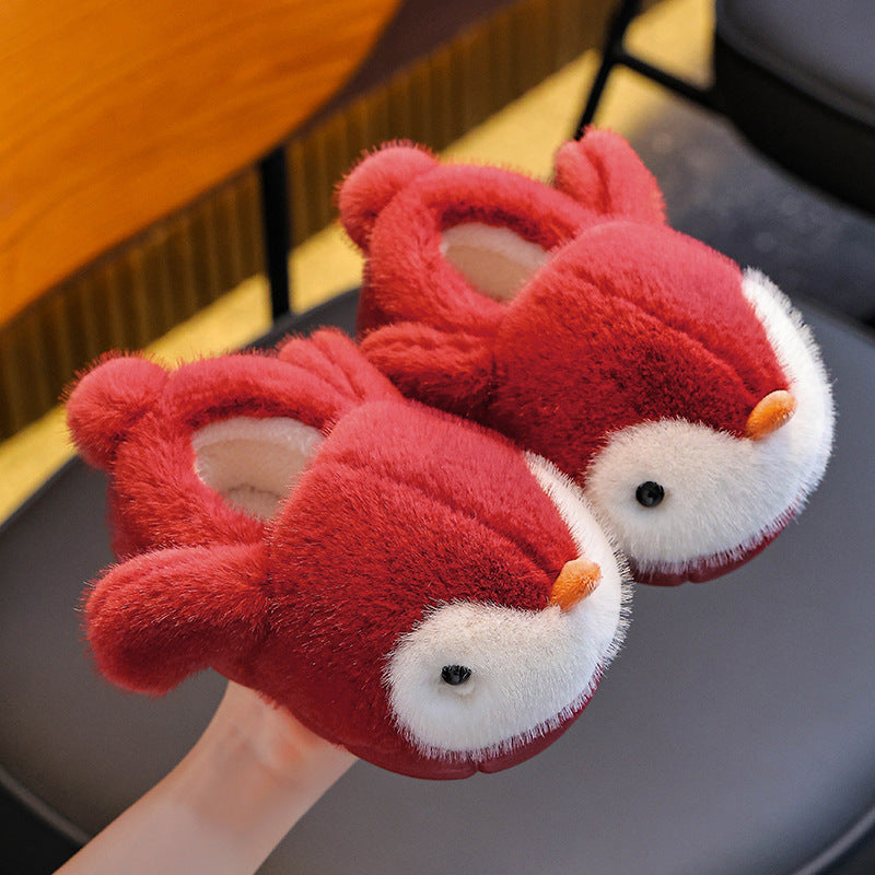 Red plush penguin slippers on a gray surface.