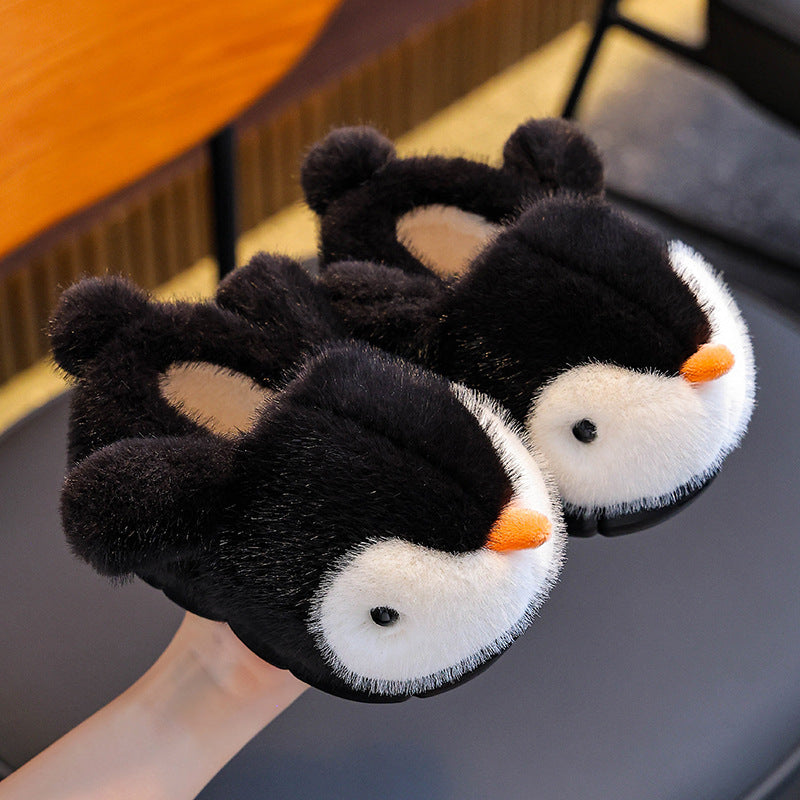 Pair of black penguin-shaped slippers on a chair