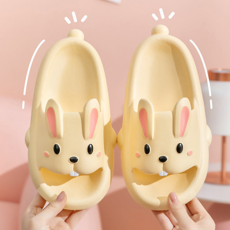 Pair of cartoon rabbit slippers held against a pink background