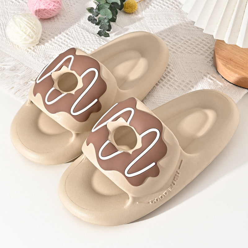 Beige slippers with brown donut design on a white surface