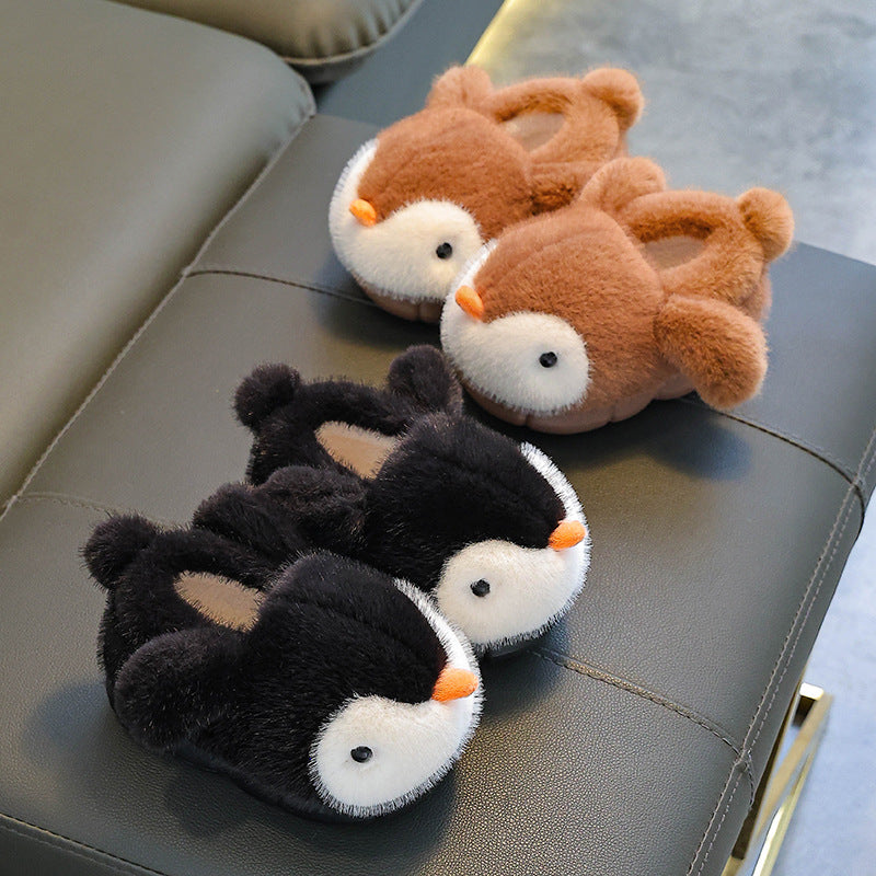Pair of penguin-themed slippers on a reflective surface