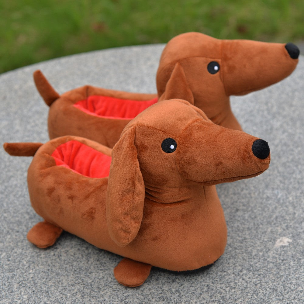 Novelty dachshund-shaped slippers with red interiors on a gray surface.