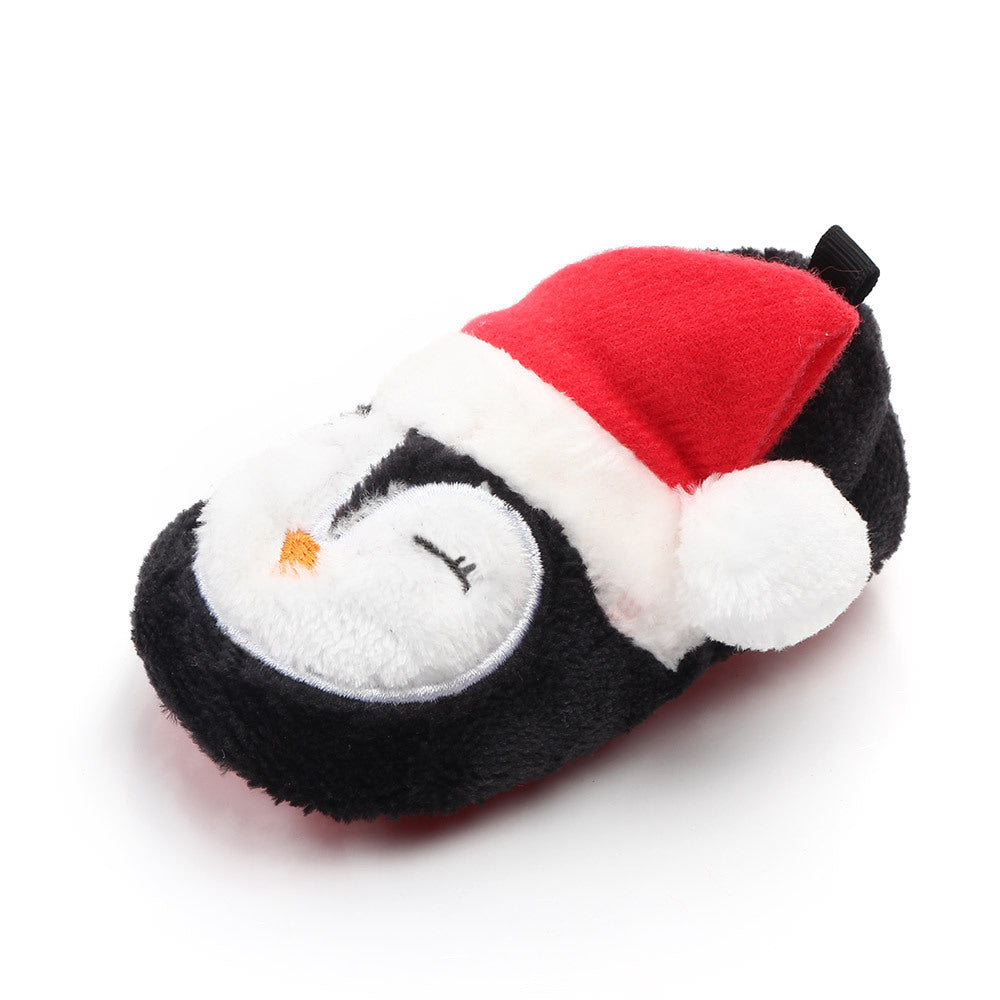 Plush penguin slippers with a Santa hat on a white background