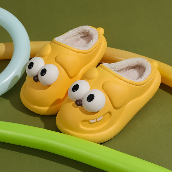 Yellow slippers with cartoon face dog design on a green background