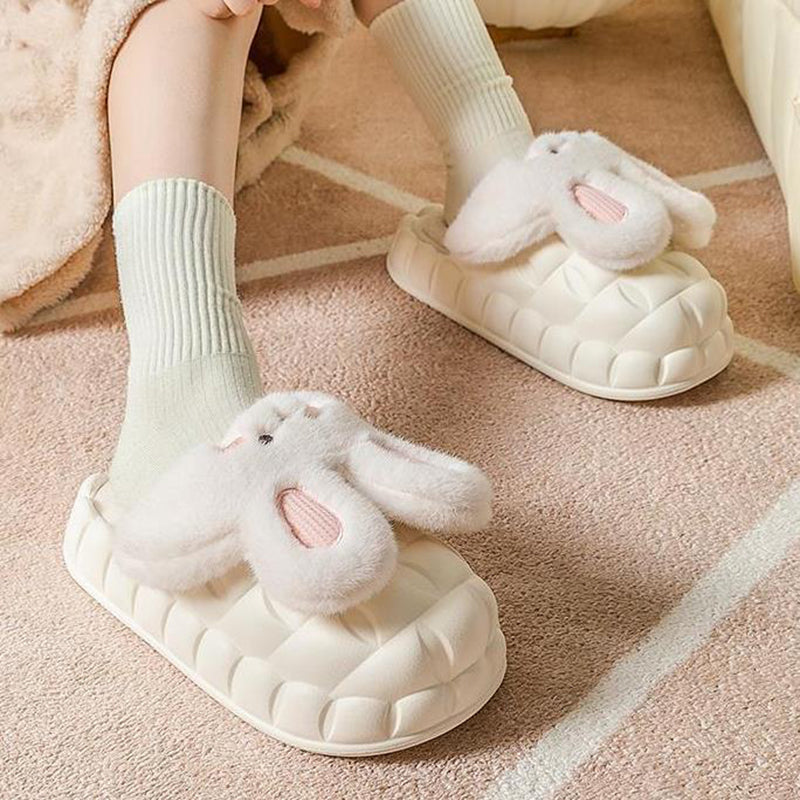 White bunny slippers worn on a pink carpet