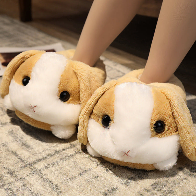Pair of rabbit-shaped slippers worn by a person on a carpeted floor.