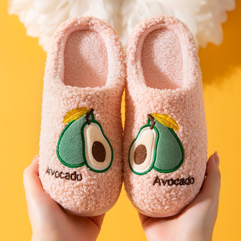 Pair of pink slippers with avocado design on a yellow background