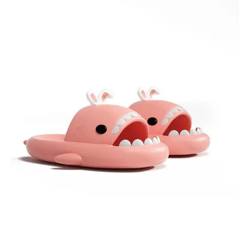 Pink shark-shaped slippers with open mouths on a white background