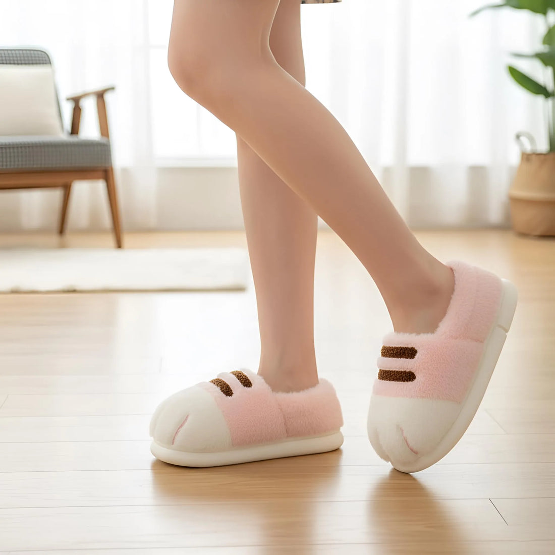 Pair of pink and white slippers with brown accents on a soft fabric background
