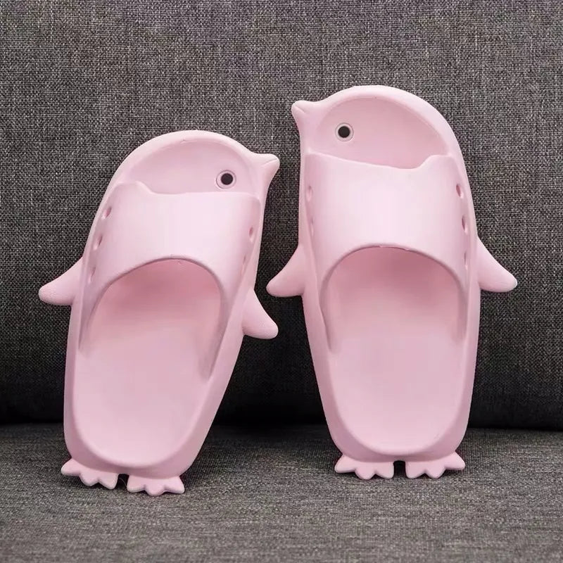 Pink penguin-shaped slippers on a gray background