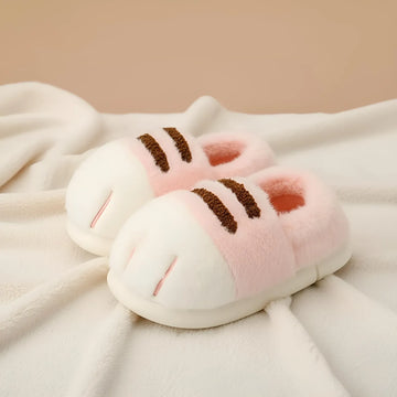 Pair of pink and white slippers with brown accents on a soft fabric background