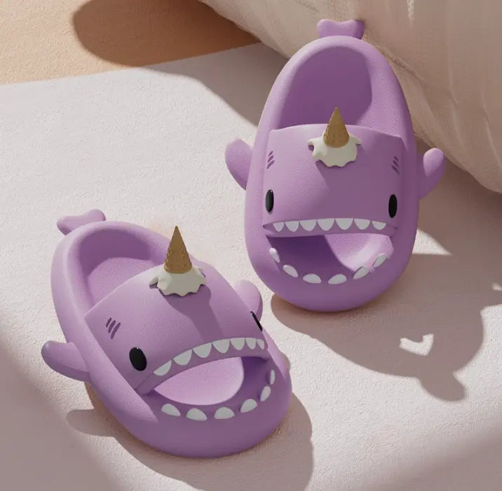 Purple shark sandals with unicorn horns on a light surface