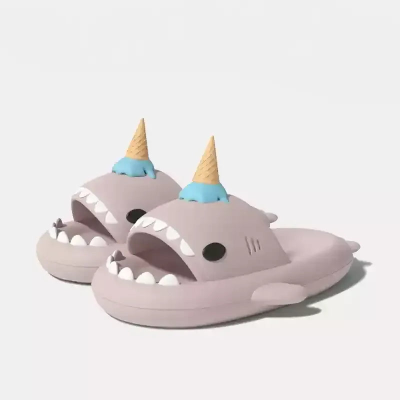 Shark-shaped slippers with ice cream cone hats on a light gray background