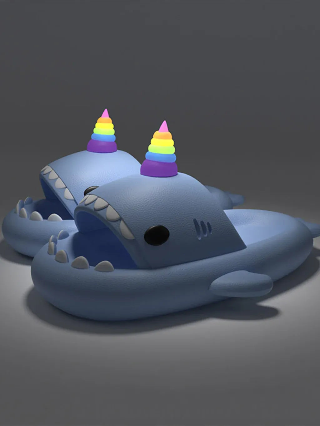 Blue shark-shaped toy with rainbow unicorn horn on a dark background