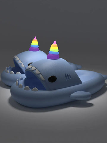 Blue shark-shaped toy with rainbow unicorn horn on a dark background