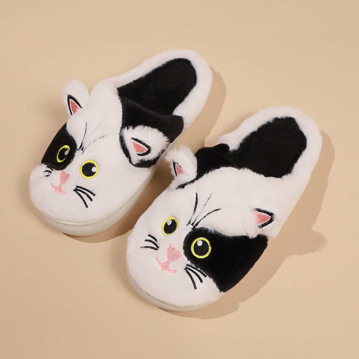 Pair of cat-themed slippers on a beige background